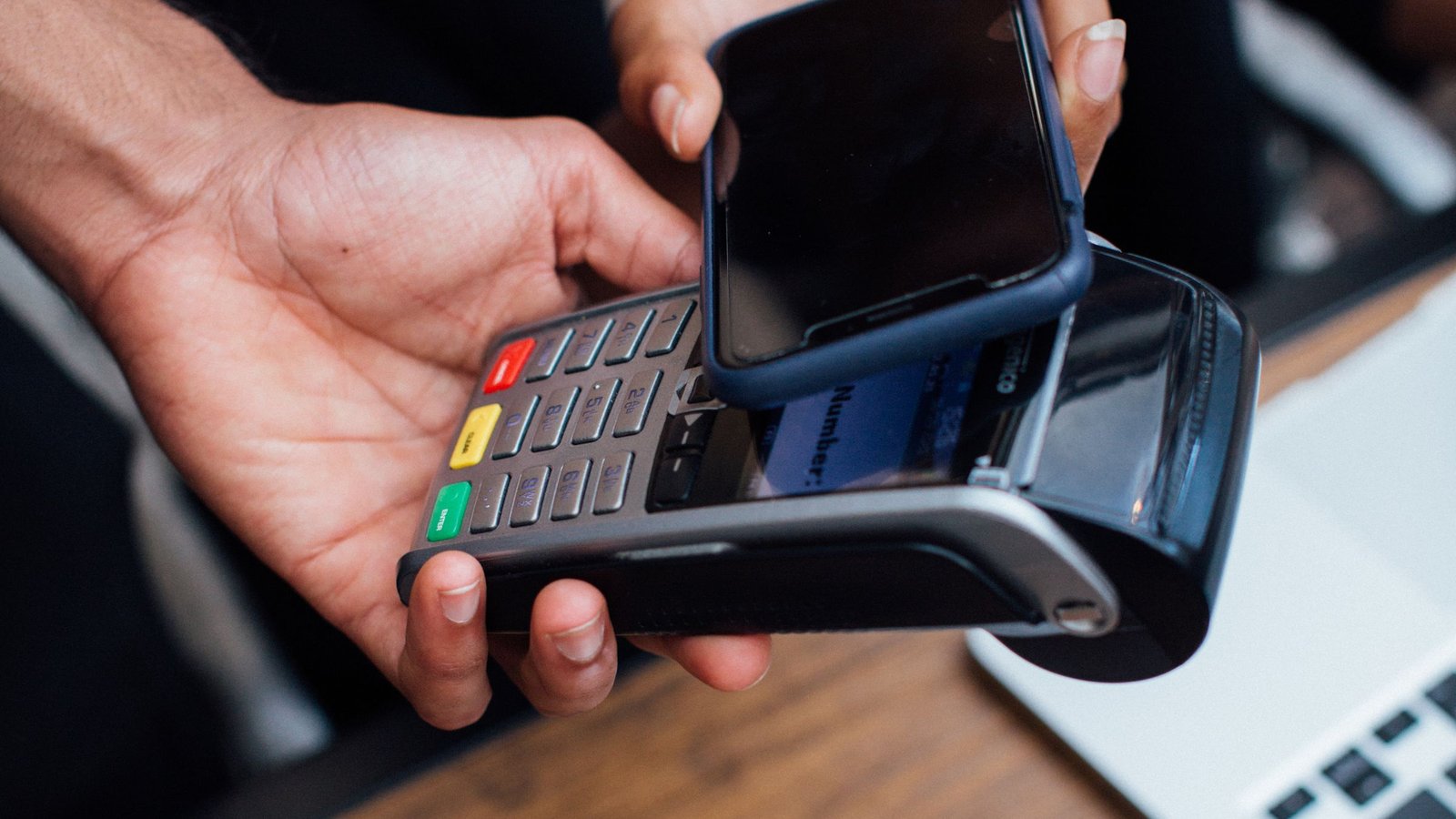 Smartphone contactloos tegen een betaalterminal, zoals betalen bij een Apple Pay casino