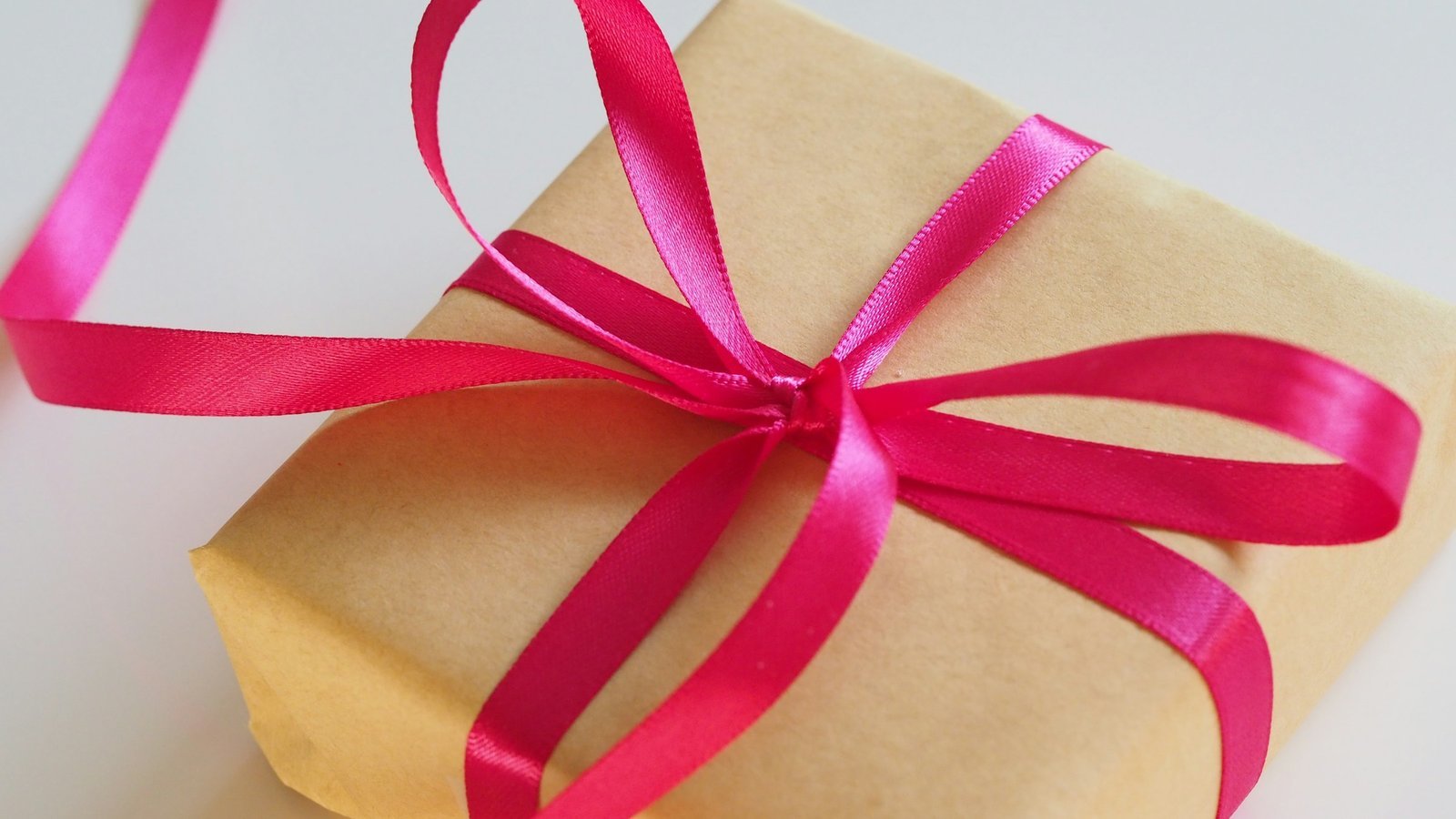 Cadeau met roze lint als symbool voor een bonus zonder inzetvereisten