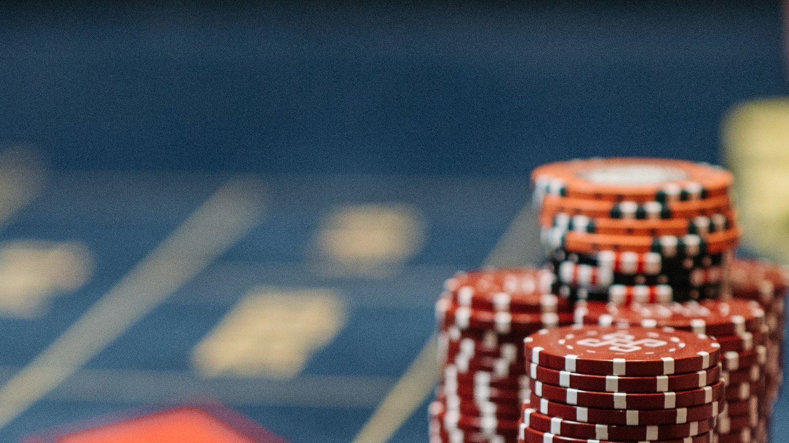 Stapels rode en oranje fiches op een speltafel, uitleg over de casino bonus