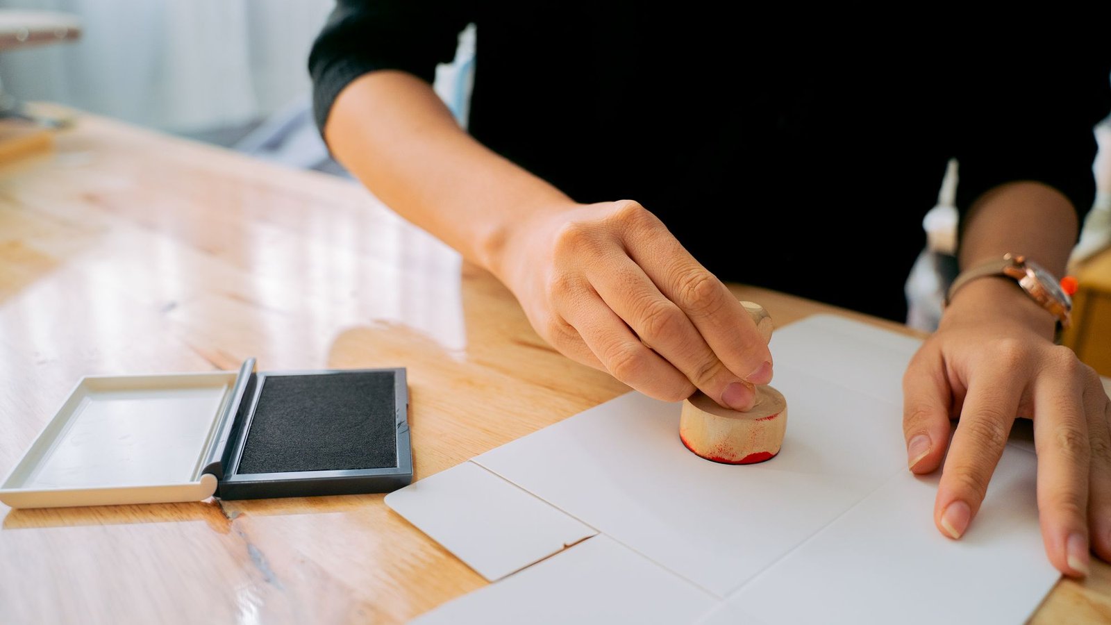 Hand zet een officiële stempel op een document, net als bij een ksa vergunning