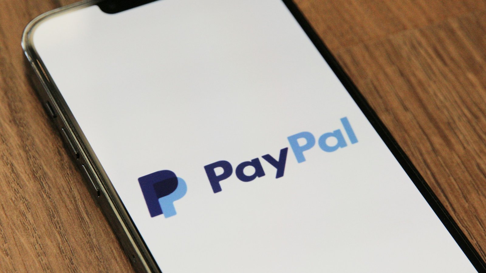 Smartphone met PayPal-logo op houten tafel, betalen via online casino paypal