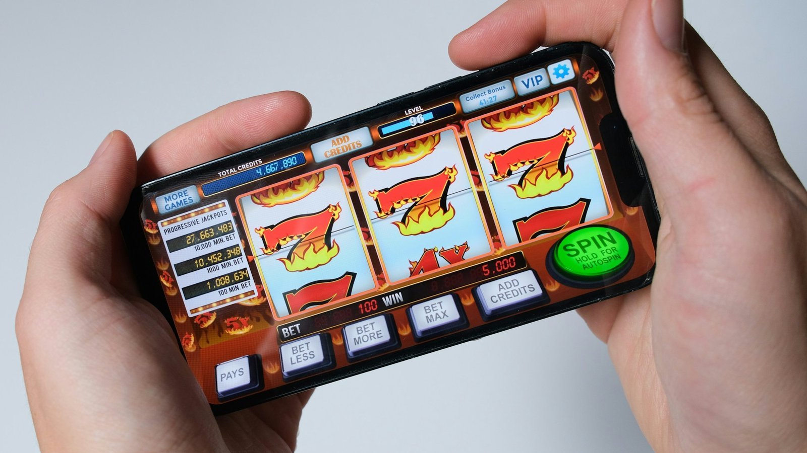 Twee handen houden een smartphone vast met een klassieke gokkast, online slots spelen