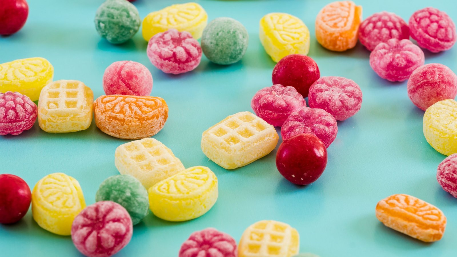 Kleurrijke snoepjes op een turquoise achtergrond, de snoepwereld van Sweet Bonanza
